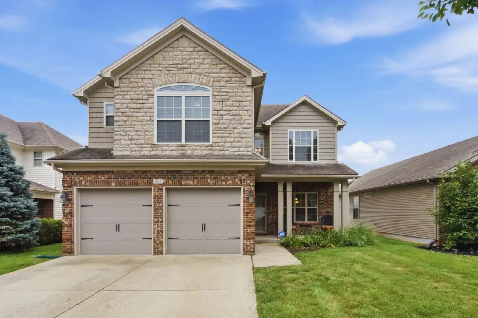 Two-story stone and brick new construction home with a two-car garage in a north Lexington KY subdivision