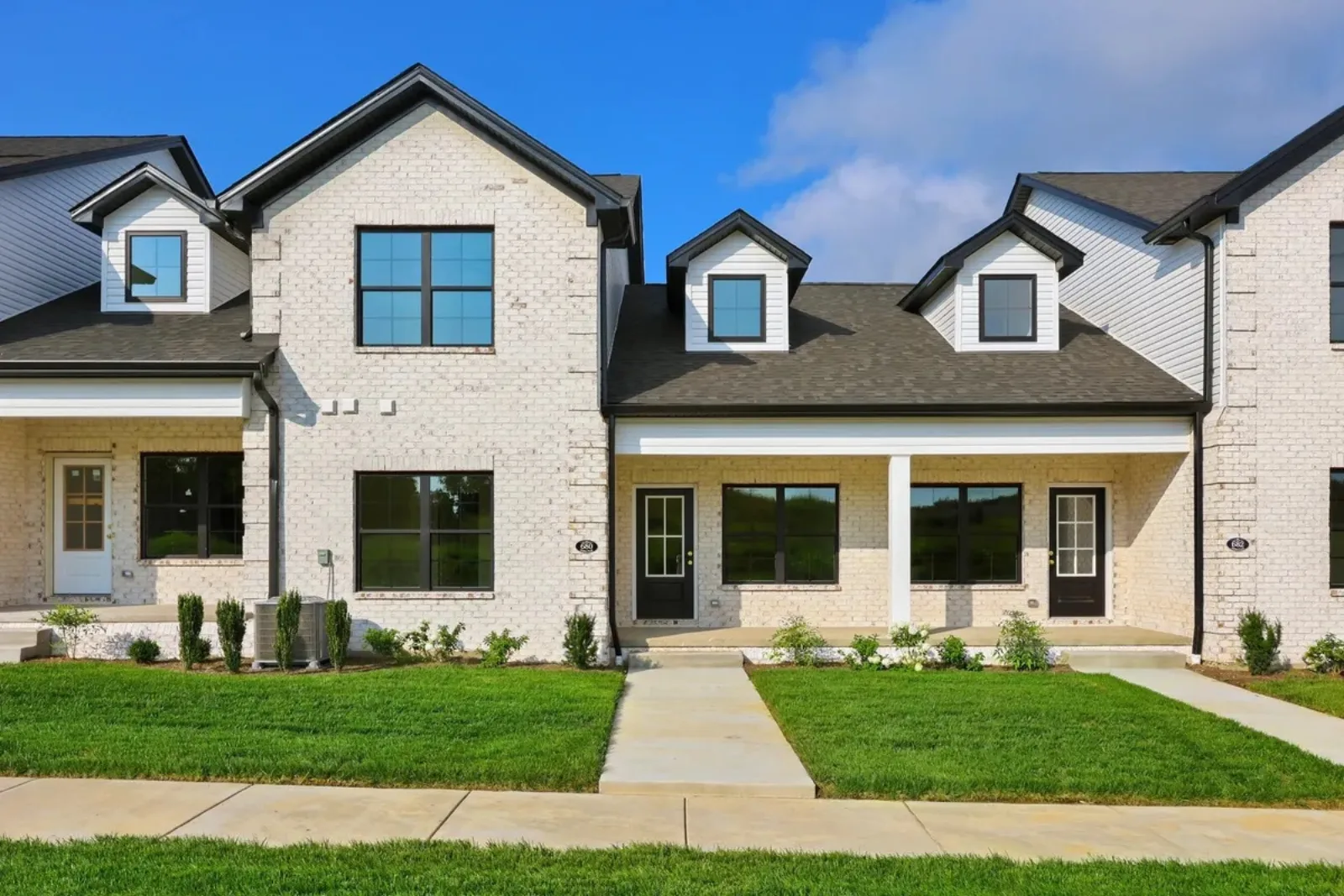 Newly built painted-brick attached homes with black windows in north Lexington KY, part of a 2025 new construction neighborhood