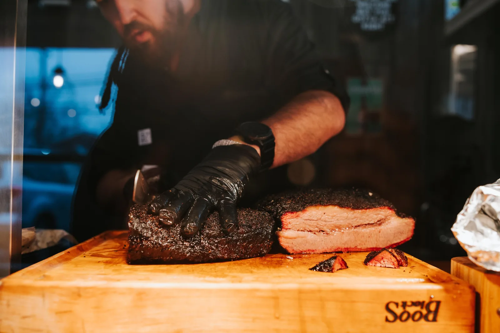 Pitmaster slicing smoked brisket at a Lexington KY restaurant