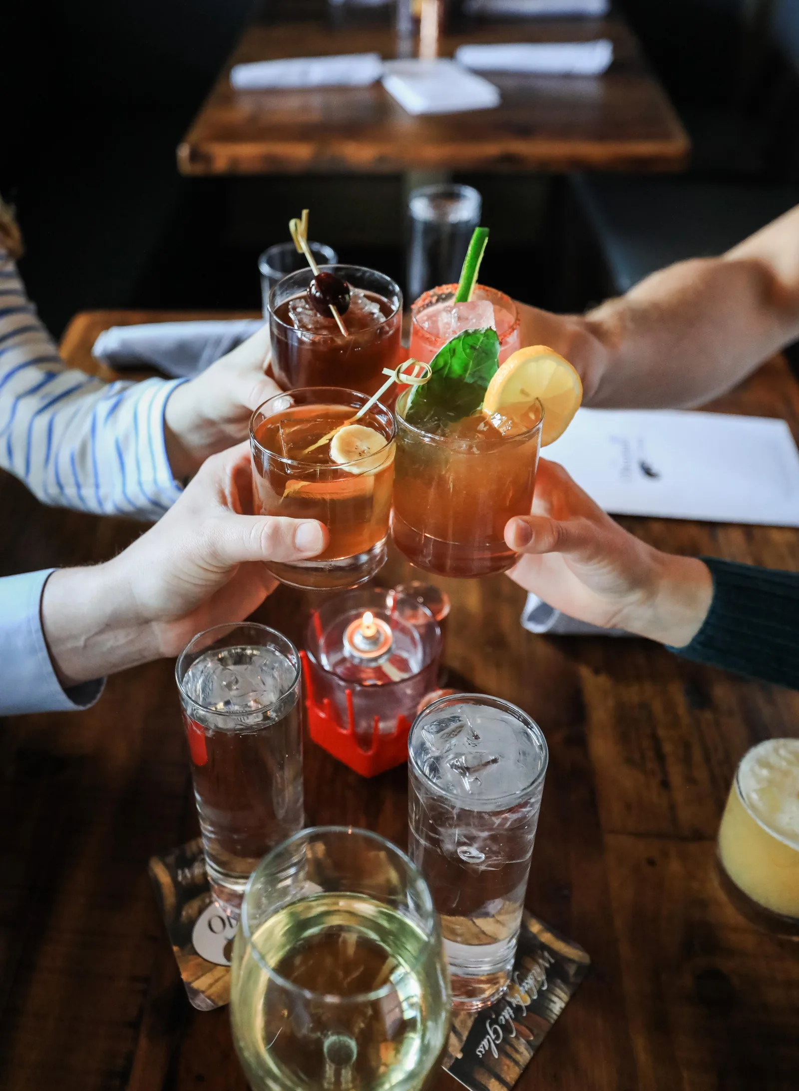 Friends toasting drinks over small plates at a Lexington neighborhood spot