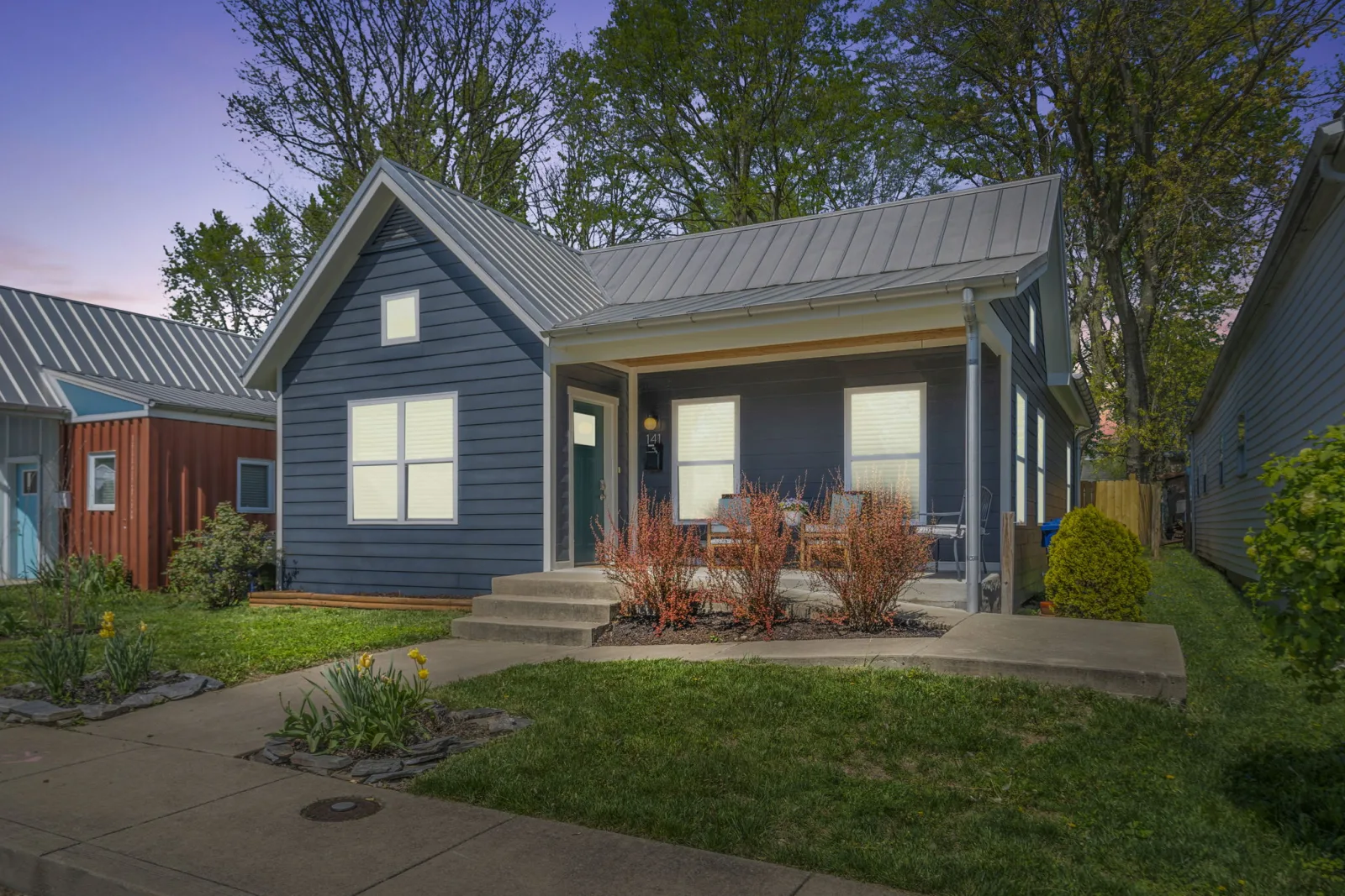 A restored navy cottage with a metal roof and covered porch near downtown Lexington KY