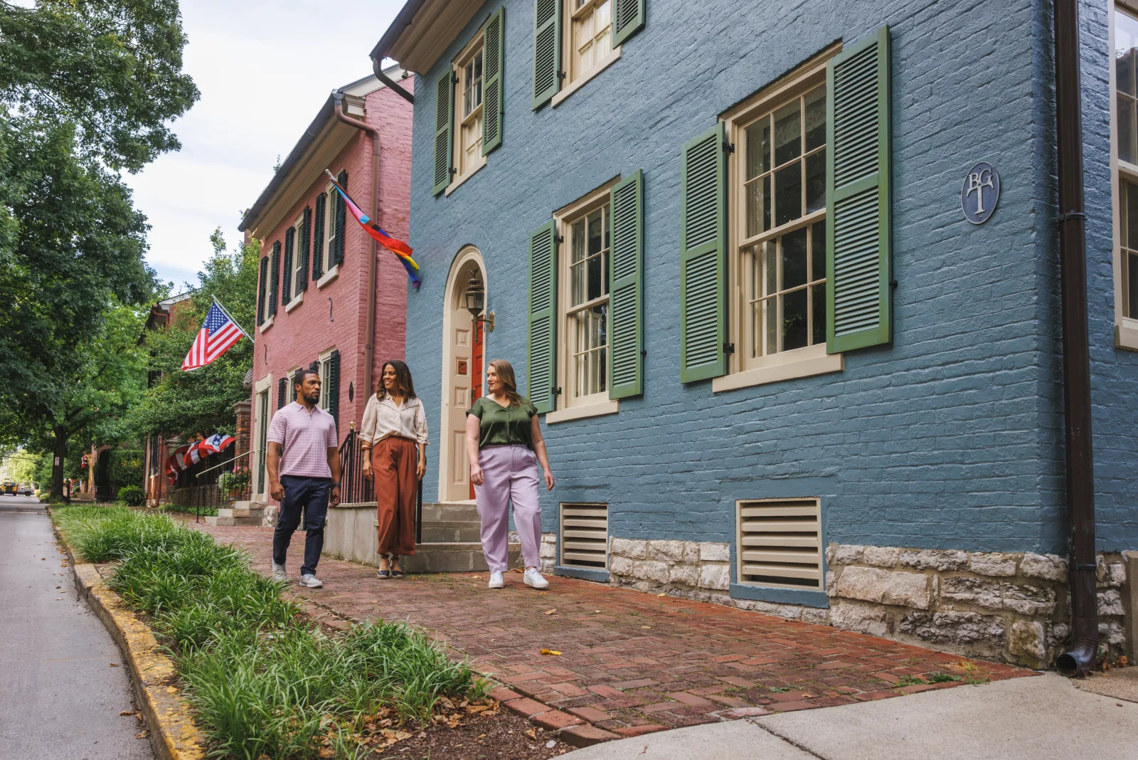 People walking a brick sidewalk past historic townhouses in Lexington KY