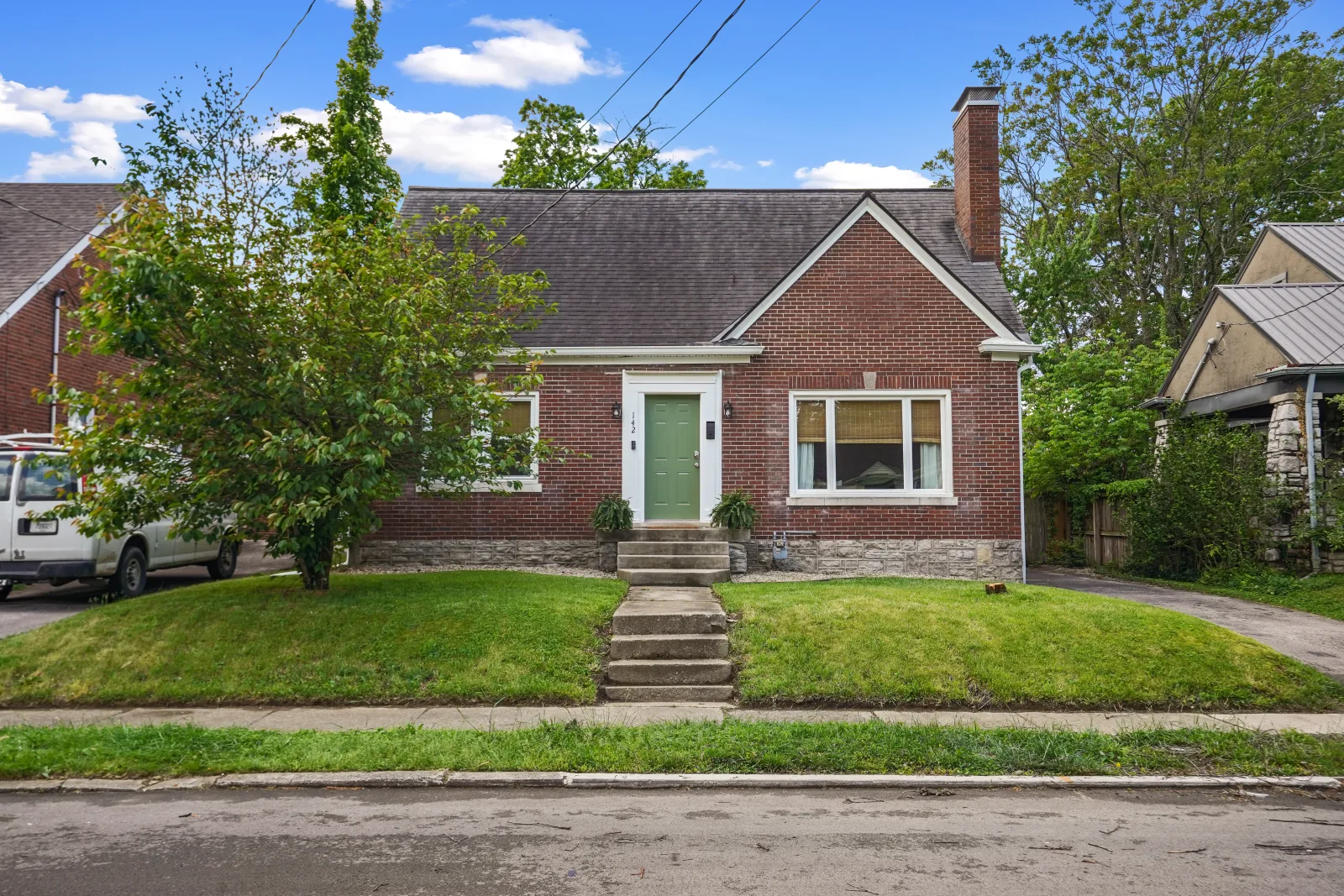 A brick cottage-style home with a manicured lawn on an established Lexington street