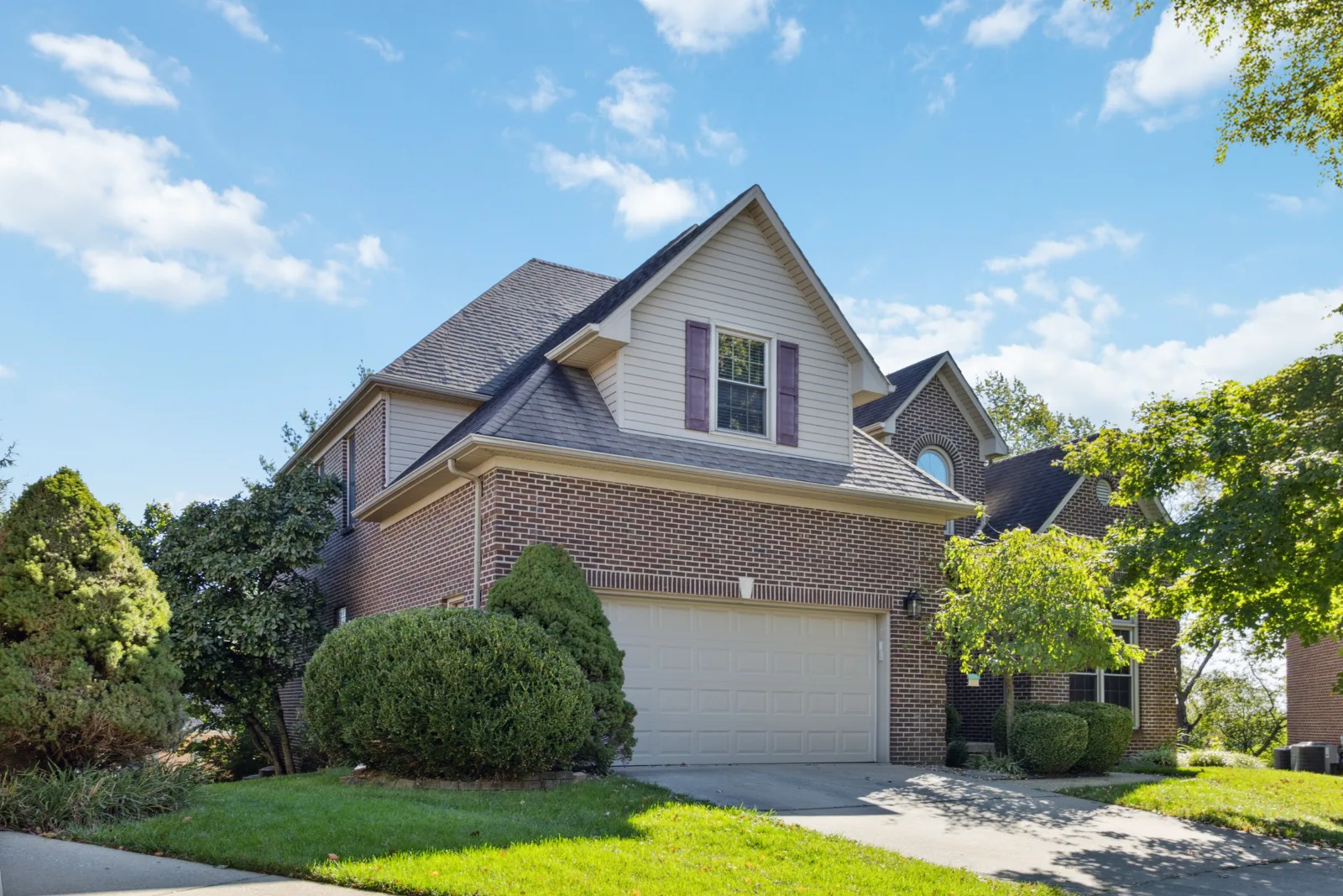 A brick-and-siding home with a two-car garage on a quiet suburban Lexington street