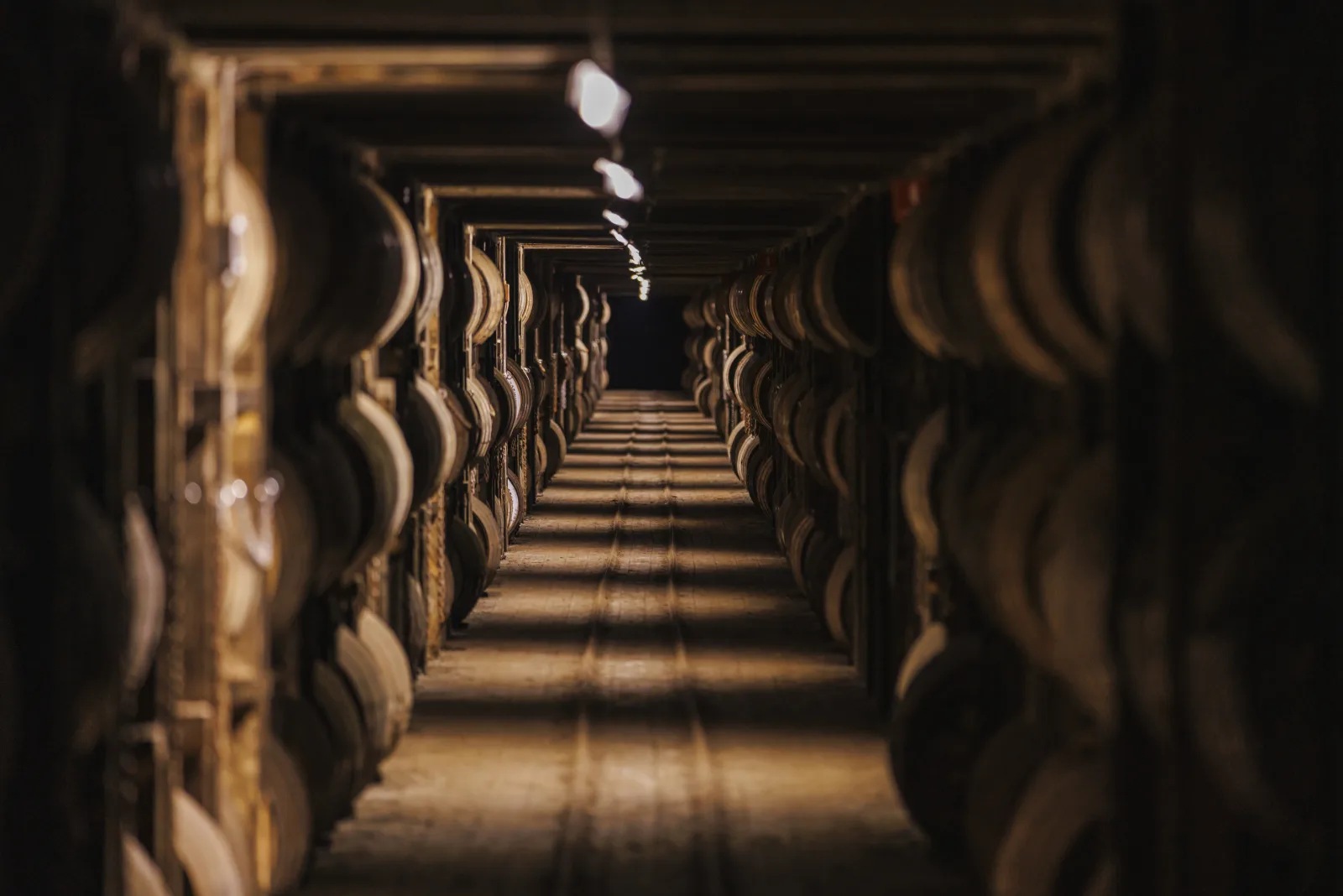 An aisle of aging bourbon barrels in a Kentucky rickhouse
