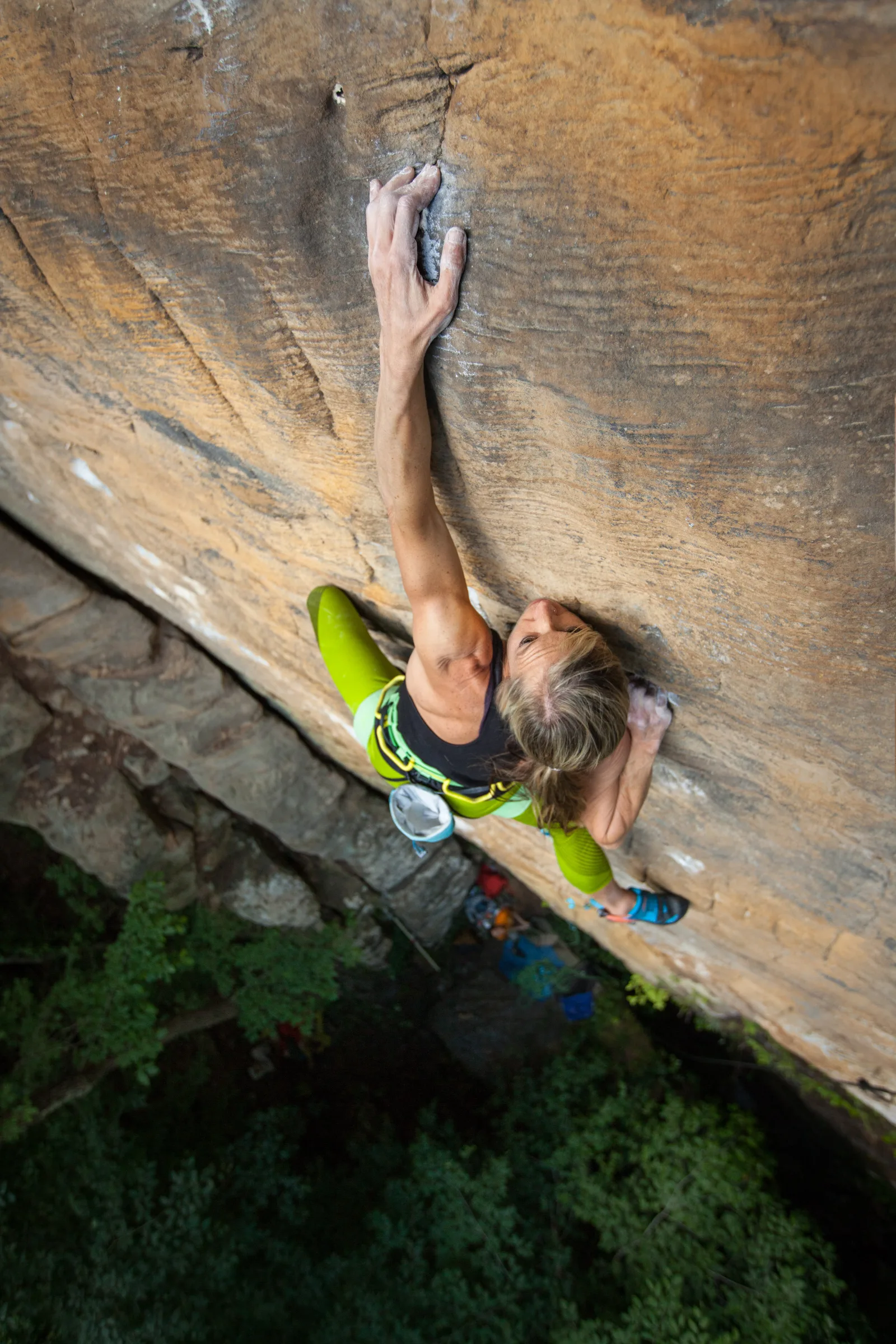 A rock climber gripping an overhanging sandstone cliff at Red River Gorge near Lexington KY