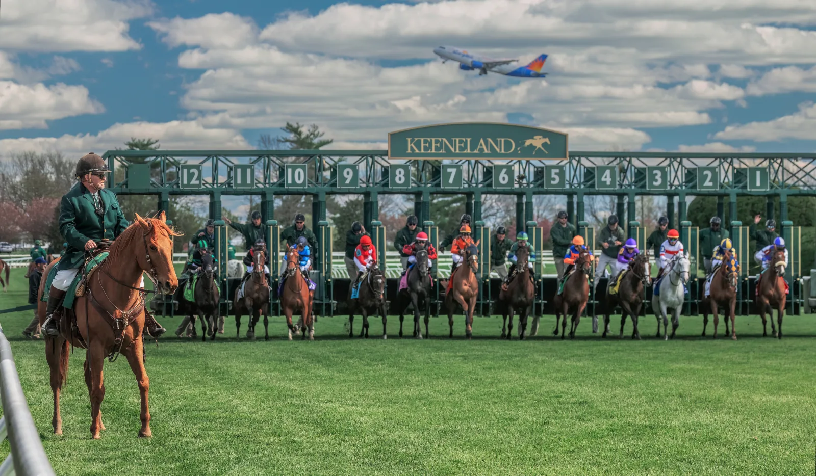 A full field of horses breaking from the starting gate at Keeneland race course in Lexington KY