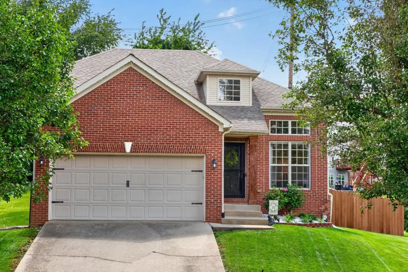 Red brick two-story home with a two-car garage in Lexington KY, the kind of house a VA loan buys with nothing down